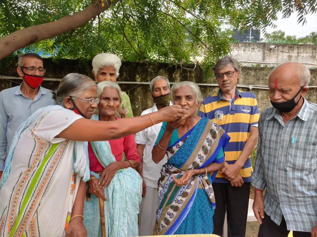 Volunteers sharing a warm meal with elderly beneficiaries outdoors